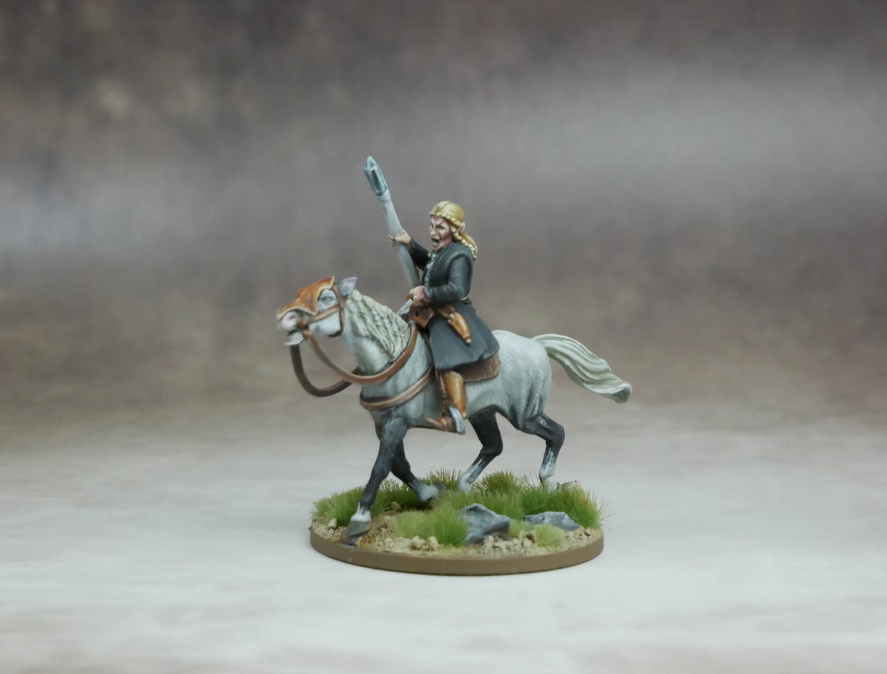 Elf High Mage riding a grey horse, wielding a spear on grassy terrain.