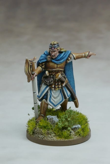 Elven Command Group leader figurine wielding a weapon in a forested base, ready for battle.